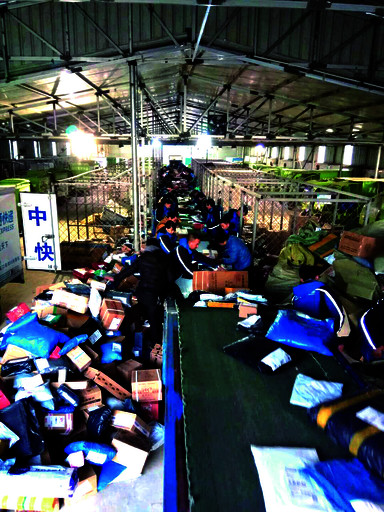 11月14日上午,中通快递河南鹤壁分公司分拨中心流水线旁,快递员忙着