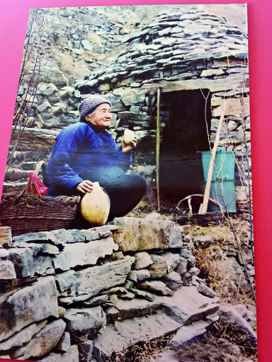 上世纪90年代,靳月英在大鳌山植树时坐在石屋前吃干馒头.