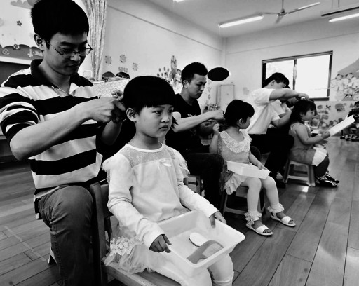 5月27日,在江苏省苏州市平江实验幼儿园,爸爸们在参加给孩子"扎辫 ""